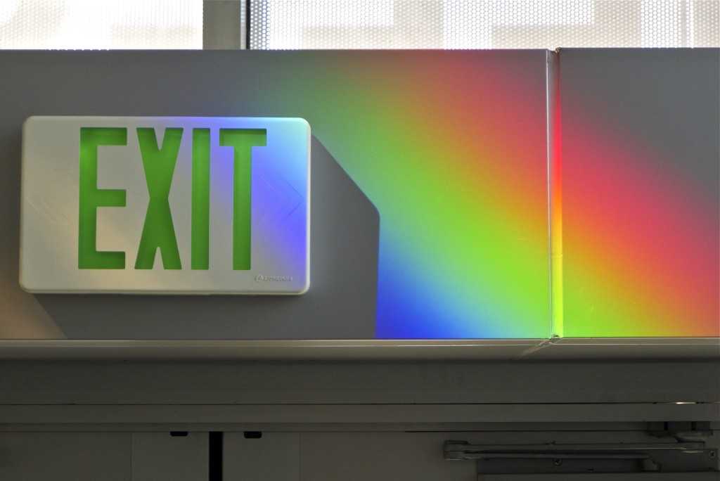 Solar rainbow prisms paint the exit sign. Erskine Solar Art