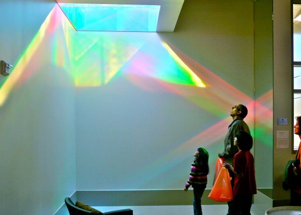 viewers examine solar skylight of Library Rainbow Art Installation
